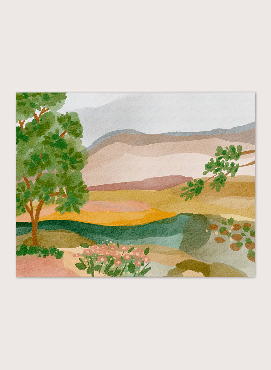 A framed landscape art print featuring a stylized watercolor scene with green trees, layered hills, and a river. Shop Peaceful Valley View by Nikita Jariwala, a serene landscape wall art print poster featuring rolling hills, distant mountains, wildflowers, and soft green tones.