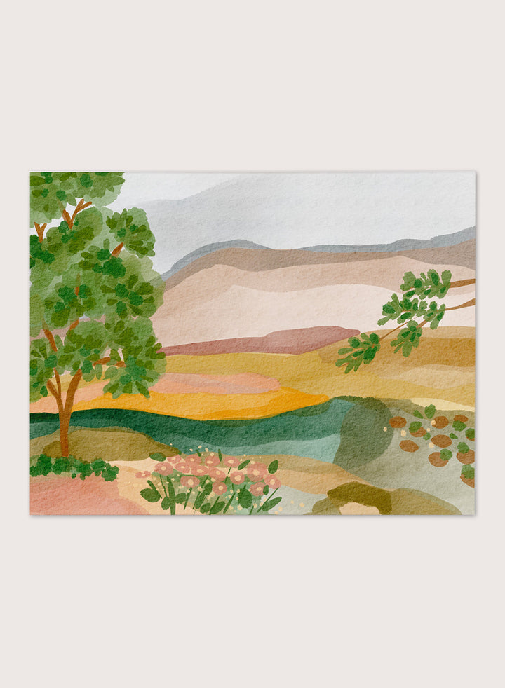 A framed landscape art print featuring a stylized watercolor scene with green trees, layered hills, and a river. Shop Peaceful Valley View by Nikita Jariwala, a serene landscape wall art print poster featuring rolling hills, distant mountains, wildflowers, and soft green tones.
