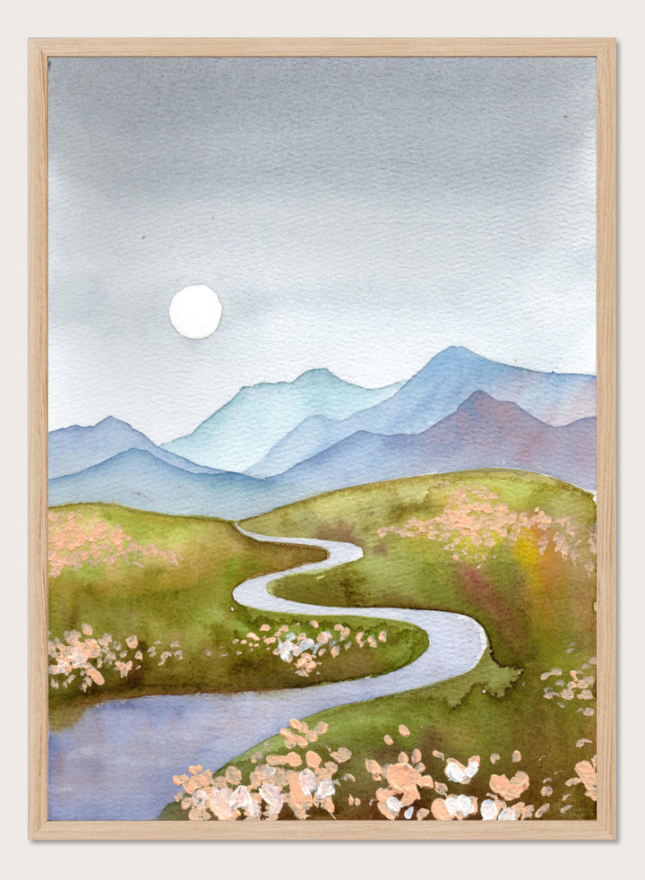 Watercolor landscape painting of a winding river flowing through green hills with pink flowers, blue mountains in the background, and a white sun in a gray sky. Shop Serene Mountain Path by Ekaterina Prisich, a landscape art print featuring a winding valley path, blue mountains, soft flowers, and a white moon.