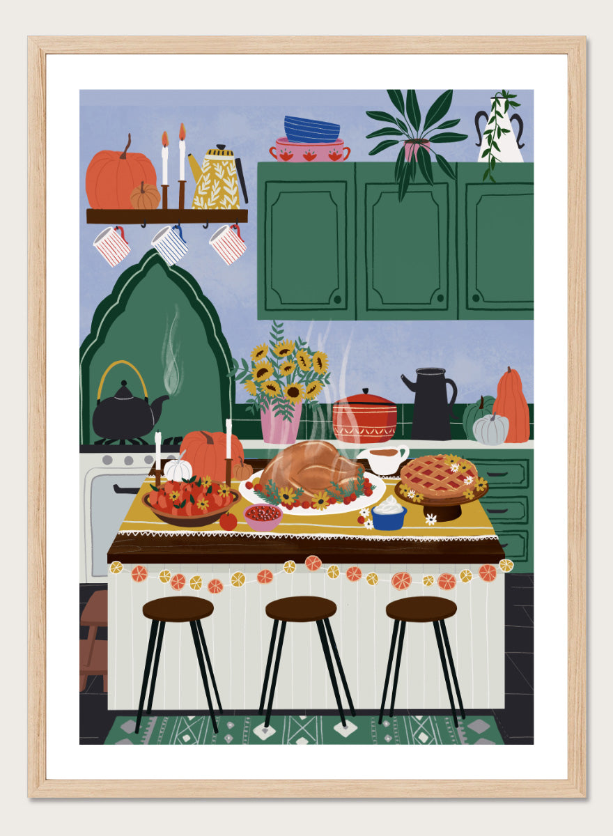 A framed art print depicting a cozy, stylized autumn kitchen scene with a large roasted turkey on a table covered in fall dishes, green cabinets, pumpkins, and three bar stools. Cozy Thanksgiving Kitchen by Ceyda Alasar kitchen art print featuring a turkey feast, pie, pumpkins, flowers, candles, and warm autumn decor.