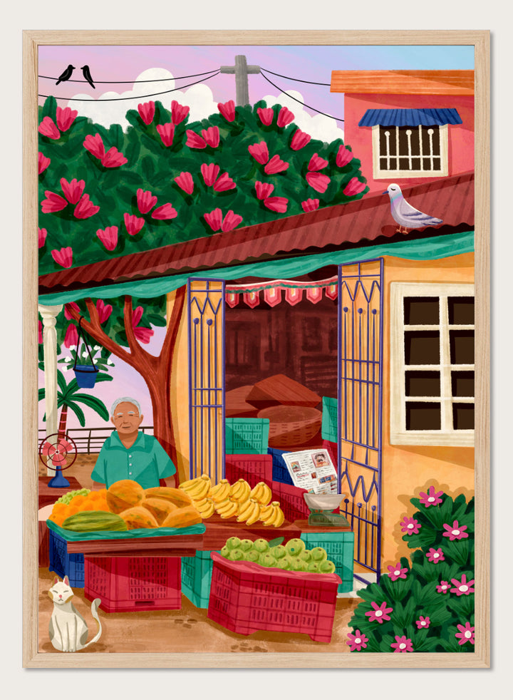 A colorful illustrated street market scene with a vendor standing behind tables of fruit and vegetables, a flowering tree, a house with pink flowers, crates, a pigeon on the roof, birds in the sky, and a white cat in the lower left. Colorful fruit stand art print by Nidhi Kachhadiya with fresh produce, floral details, and market charm. A cheerful print for kitchen or dining spaces.