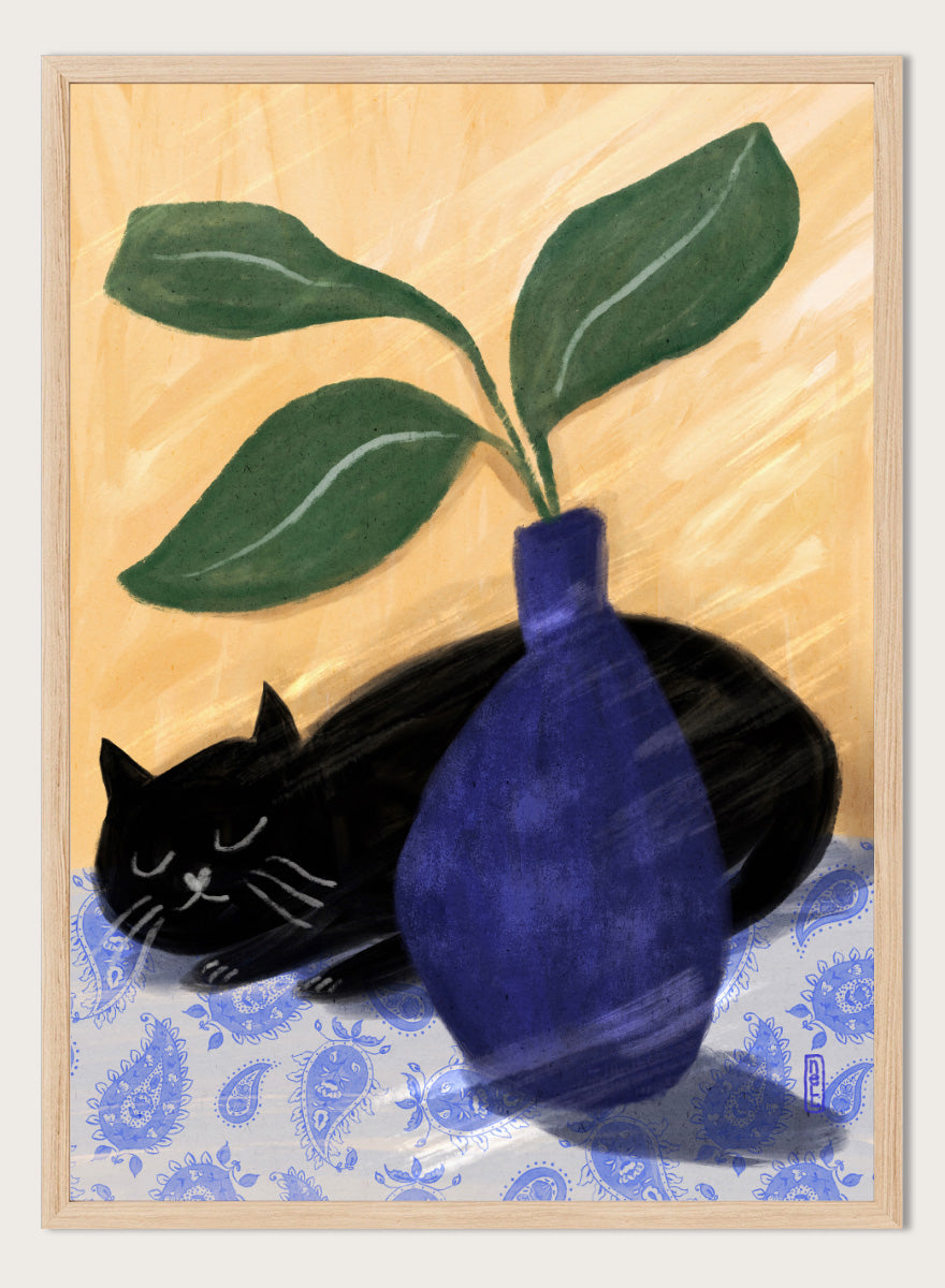 A stylized still life painting featuring a black cat lying on a blue-and-white patterned surface beside a dark blue vase with green leaves, against a warm beige background. Shop the Sleeping Black Cat art print by Dirkie Nell, featuring a curled black cat, bold cobalt blue vase, green leaves and playful patterned details.