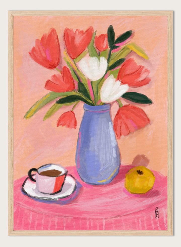 A still life painting of a bouquet of red and white tulips in a blue vase, set on a pink tablecloth next to a cup of coffee and a yellow fruit, against a peach background. Shop Fresh Tulips and Coffee by Dirkie Nell, a colorful floral still life art print featuring tulips, coffee, a blue vase, and warm pink and peach tones.