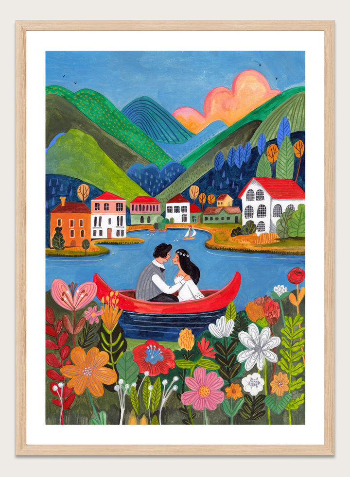 Couple in a red boat on a lake with mountains and houses in the background, surrounded by colorful flowers. Just Married Couple in a Boat by Caroline Bonne Müller is a romantic art print featuring couple illustration, lake scene, colorful flowers, and modern aesthetic wedding artwork.