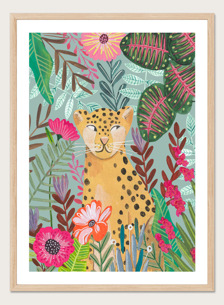 Illustration of a cheetah surrounded by colorful flowers and leaves on a light blue background. Happy Leopard Tropical Flowers by Caroline Bonne Müller is a fine art print and wall poster featuring a leopard with tropical flowers in a modern aesthetic style.