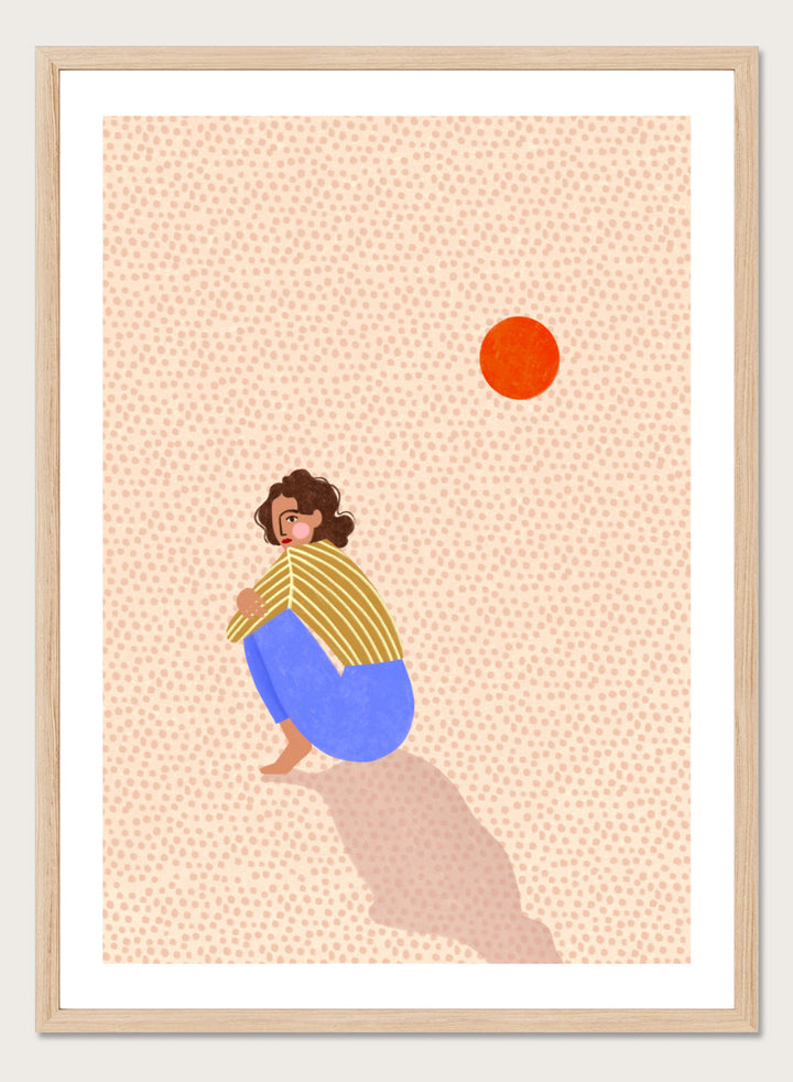 A minimalist art print featuring a stylized illustration of a person crouching in blue pants and a yellow striped top, looking up at a small orange sun against a light beige dotted background, framed with a white mat and black border. Pensive Woman Under Sun by Bea Müller art print featuring a seated woman beneath an orange sun in bold blue, mustard, and soft neutral tones.