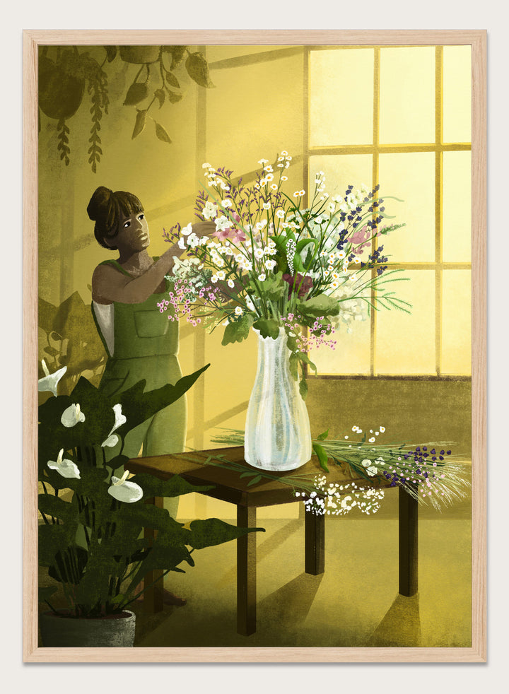 Woman in a green dress holding a bouquet of flowers in a softly lit room. In the Cracks of Light I Dream by Goed Blauw is a floral art print and wall poster featuring a woman arranging flowers in warm window light.