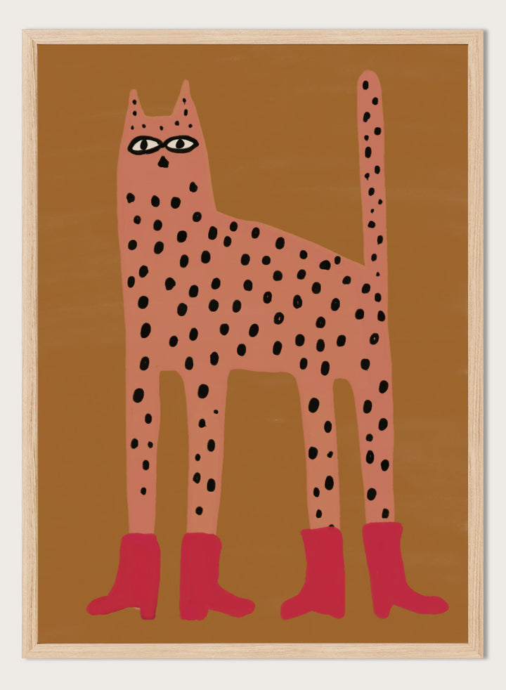 A stylized art print of a tall spotted cat in a pinkish-orange tone with black spots and bright pink boots, set against a warm brown background. Spotted Cat in Boots by The Art Concept playful cat art print featuring a pink spotted cat with long legs, red boots, and a warm ochre background.