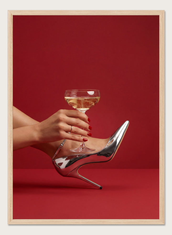 High-heeled shoe holding a glass of white wine against a red background, High Heels and Champagne by Andreas Magnusson is a fashion illustration art print featuring high heels, champagne glass imagery, bold red tones, and modern contemporary wall art style.