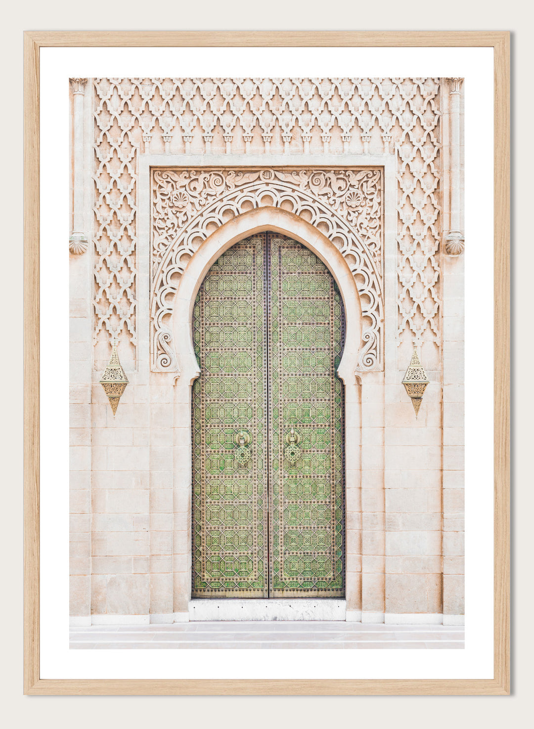 Decorative archway with ornate green door on a light stone wall. Ornate Moroccan Green Door by Henrike Schenk is a Moroccan architecture print featuring an ornate green door, Islamic patterns, and historic stone details.