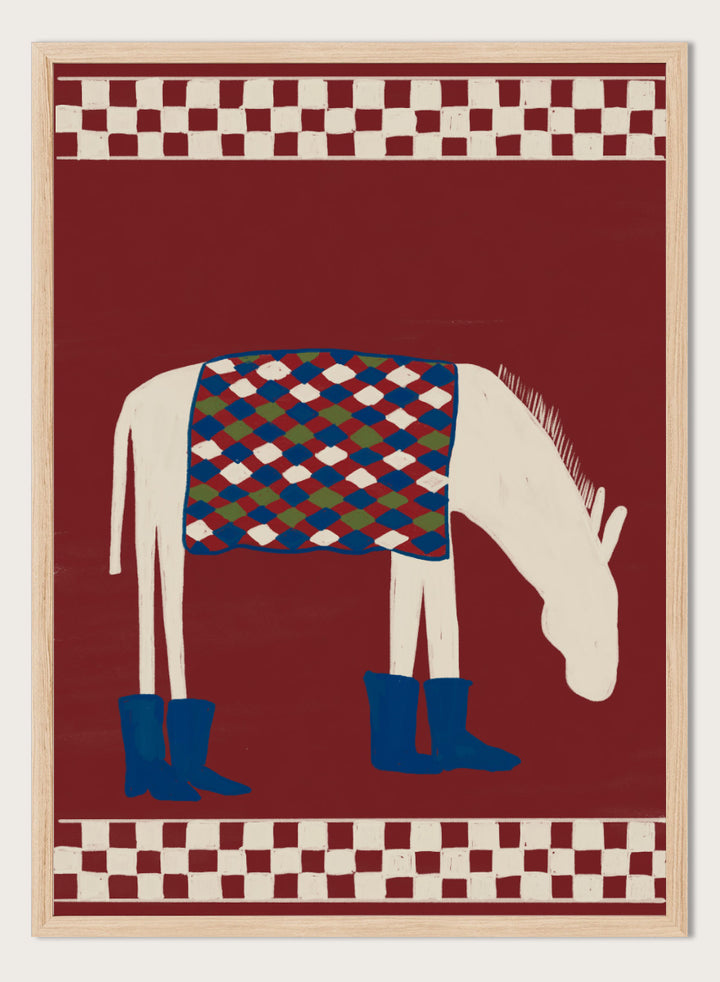 A stylized folk-art illustration of a white horse with a patterned blue, green, and red saddle blanket and blue boots, set against a dark red background with cream-and-red checkered borders at the top and bottom. Whimsical Donkey In Boots by The Art Concept animal art print featuring a white donkey in blue boots with a patterned blanket and rich red background.