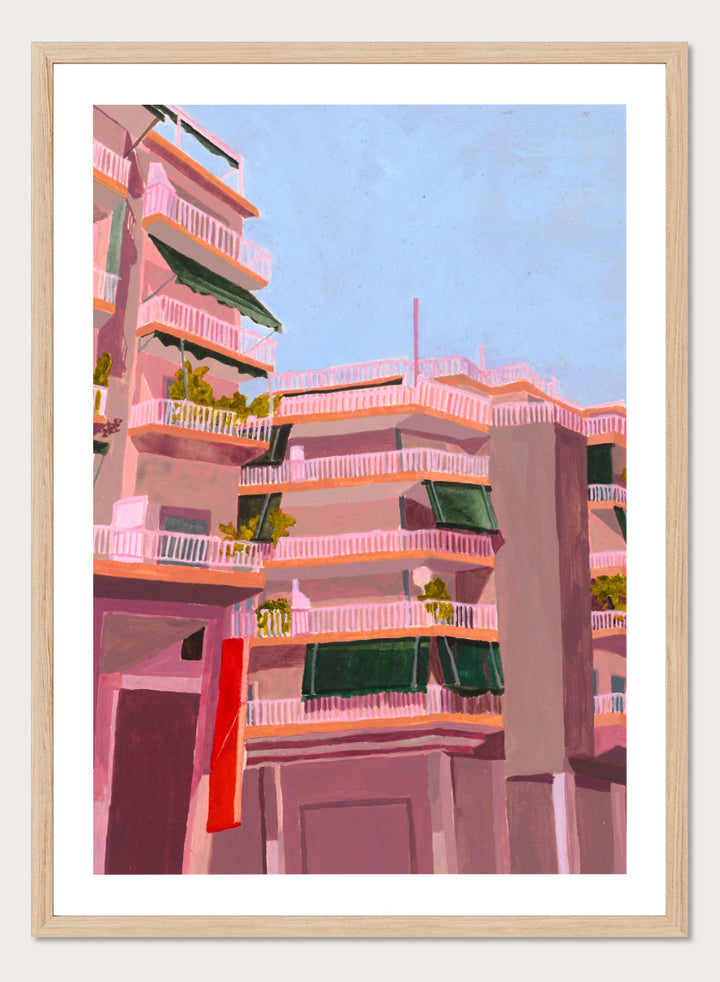 Shop Pink City Balconies by Sophia Novosel, a colorful city wall art print poster featuring pink apartment buildings, green awnings, balconies, and blue sky.