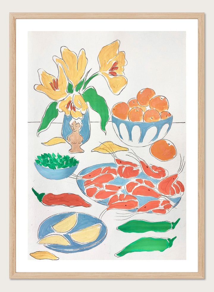 A framed still life art print featuring yellow tulips in a blue vase, bowls of oranges, red shrimp, green peppers, and yellow lemon wedges. Shop Fresh Flowers and Feast by Rushati Chowdhury, a colorful food and floral art print featuring shrimp, oranges, peppers, greens, lemon, and yellow flowers.