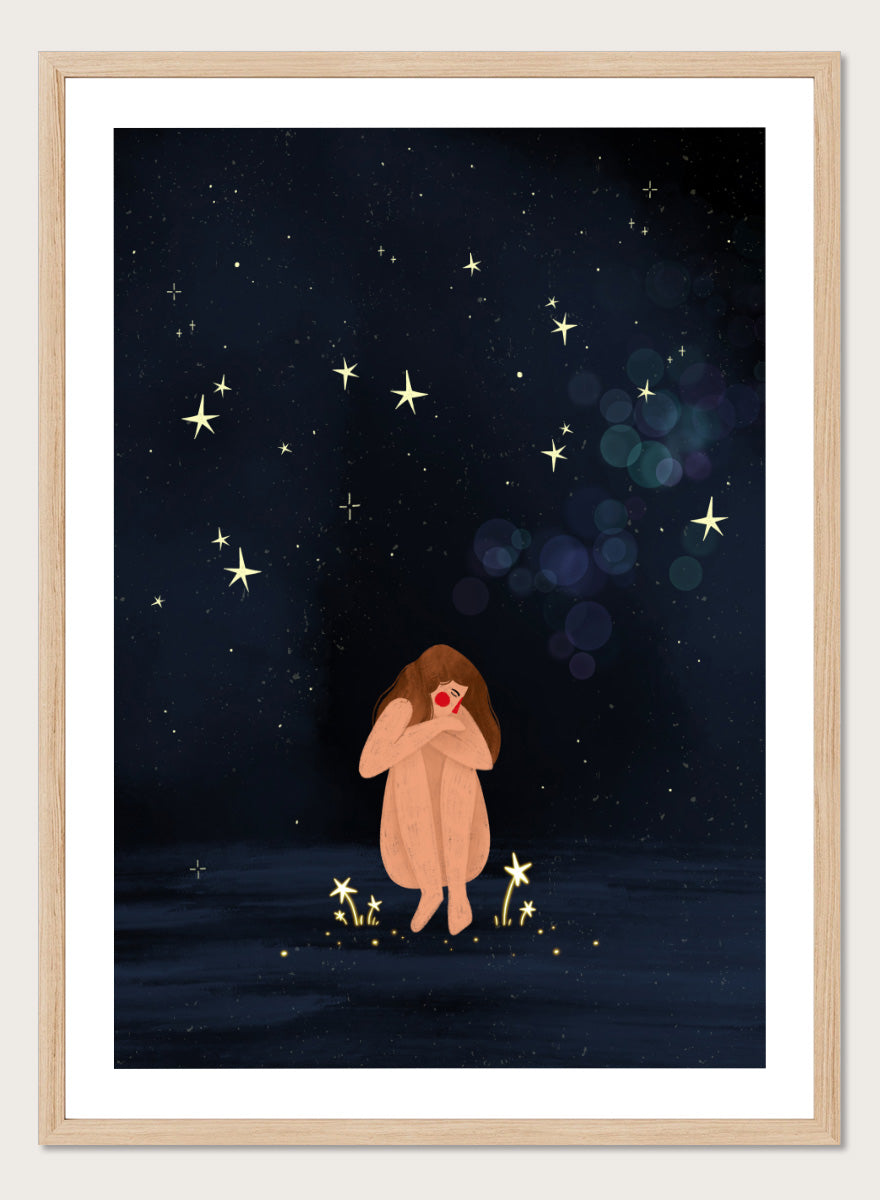A framed art print featuring a whimsical illustration of a girl sitting on a dark blue starry night sky. Shop Starlit Solitude by Bea Müller, a figurative wall art print poster featuring a solitary woman beneath a star-filled night sky in deep blue tones.