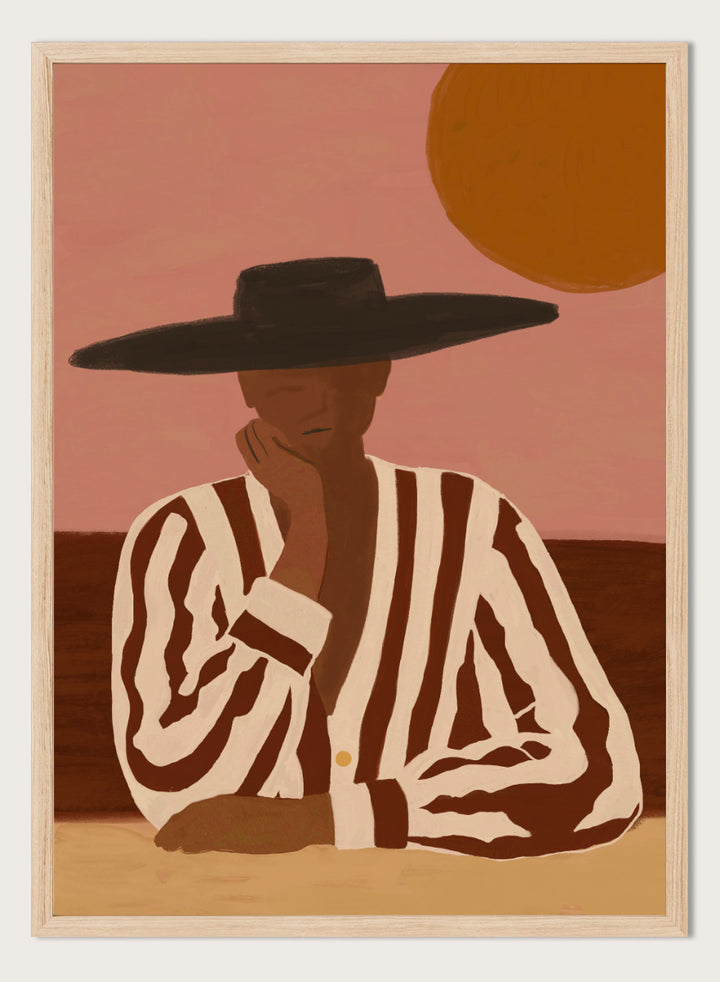 A stylized art print depicting a seated figure in a wide-brimmed black hat and a brown-and-white vertically striped shirt, set against a dusty pink sky with a large orange sun. Desert Dreamer by The Art Concept art print featuring a relaxed figure in a wide black hat, striped shirt, dusty pink sky, and warm desert-inspired tones.