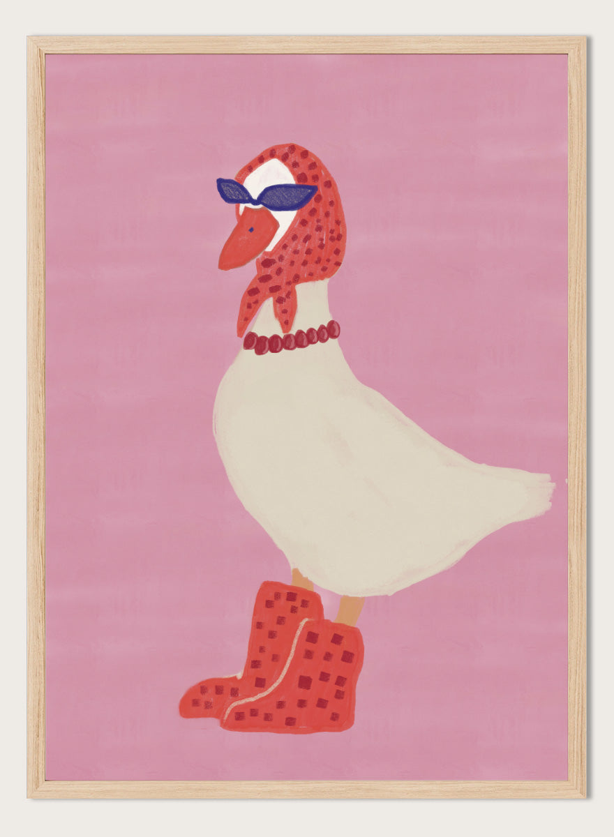 A stylized illustration of a white goose wearing a red patterned headscarf, blue sunglasses, a red beaded necklace, and red checkered boots, set against a solid pink background. Chic Goose Fashion by The Art Concept playful animal art print featuring a goose in sunglasses, a red headscarf, necklace, and bold red boots.