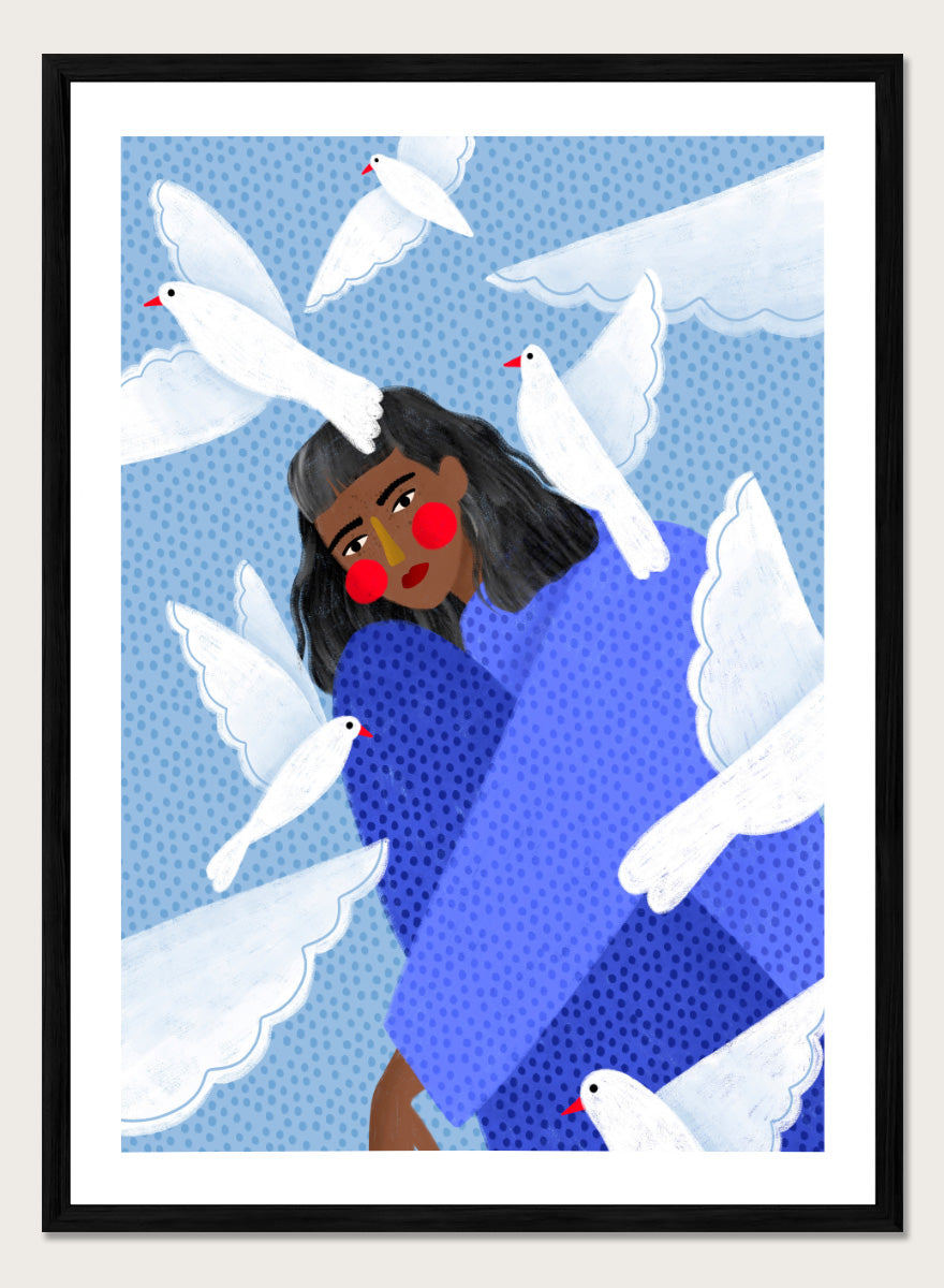 A framed art print featuring a stylized illustration of a woman with dark hair and red cheeks, wrapped in a blue patterned blanket, surrounded by white doves against a light blue dotted background. Peaceful Woman and Doves by Bea Müller art print featuring a woman in blue surrounded by white birds, layered textures, and soft modern color.
