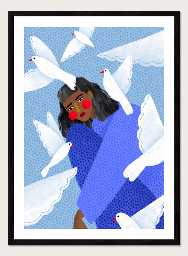 A framed art print featuring a stylized illustration of a woman with dark hair and red cheeks, wrapped in a blue patterned blanket, surrounded by white doves against a light blue dotted background. Peaceful Woman and Doves by Bea Müller art print featuring a woman in blue surrounded by white birds, layered textures, and soft modern color.