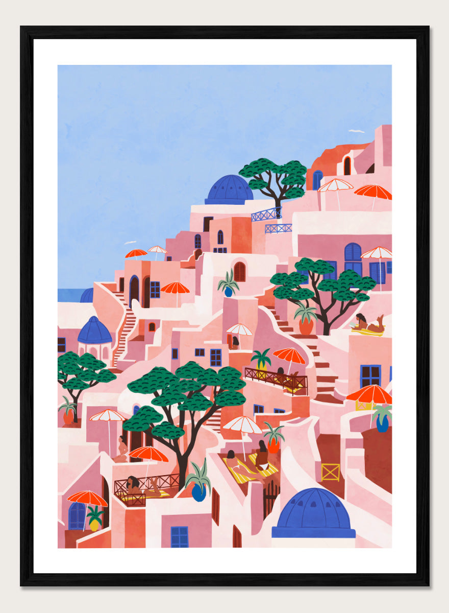 A stylized art print depicting a hillside Mediterranean village with pink and peach buildings, blue domes, green trees, and a light blue sky. Santorini Summer Dream by Ceyda Alasar art print featuring blue domes, terraced Mediterranean architecture, orange umbrellas, and sunny Greek island charm.