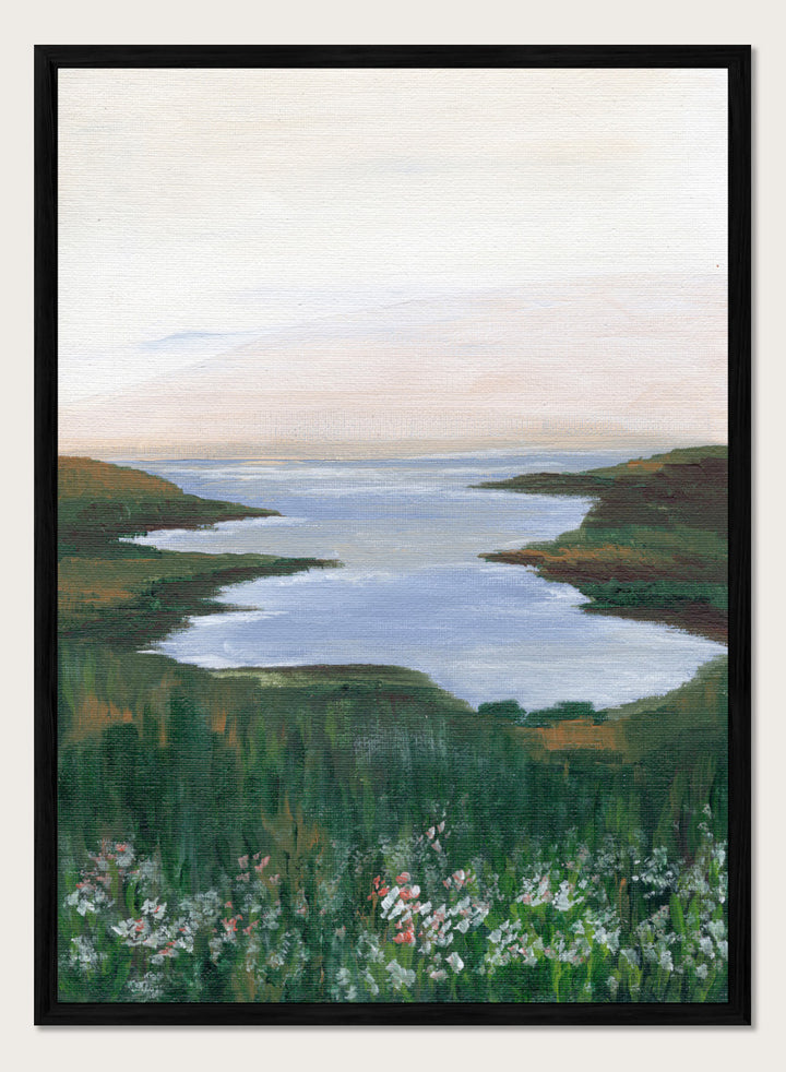 A landscape painting of a winding river or inlet between green hills, with a pale sky above and wildflowers in the foreground. Shop Wildflower Coast View by Nikita Jariwala, a coastal landscape wall art print poster featuring ocean views, green cliffs, wildflowers, and soft blue tones.