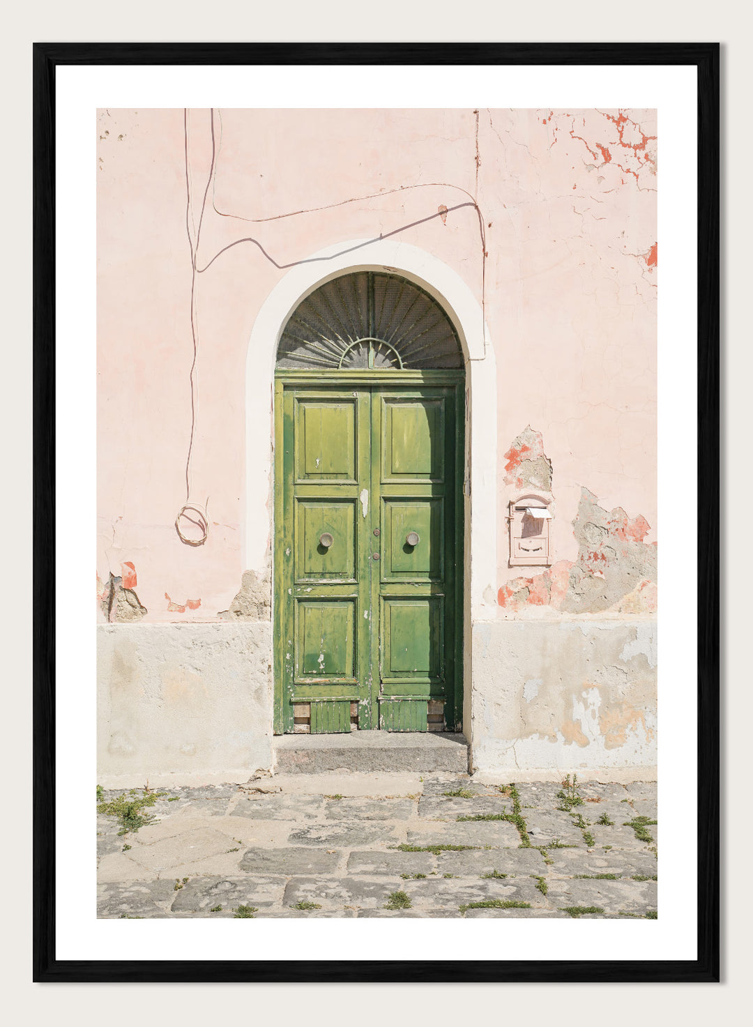 Green door on a pink wall with peeling paint. Old World Green Door by Henrike Schenk features a vintage European doorway, weathered architecture, pastel walls, travel photography, and wall art.