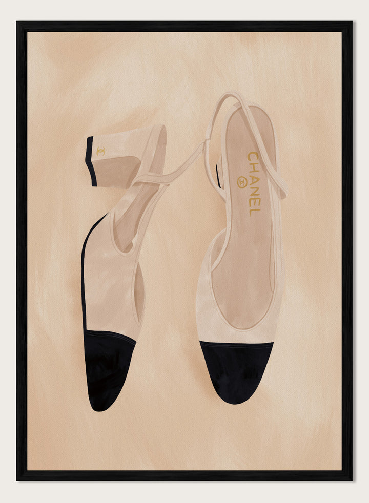 A pair of slingback flats with a beige and black color-blocked design, displayed on a textured beige background with a black border. Chic Cap-Toe Heels by Lisa Solomoniuk premium framed fine art print featuring cream slingback heels with black cap toes on a soft beige background.