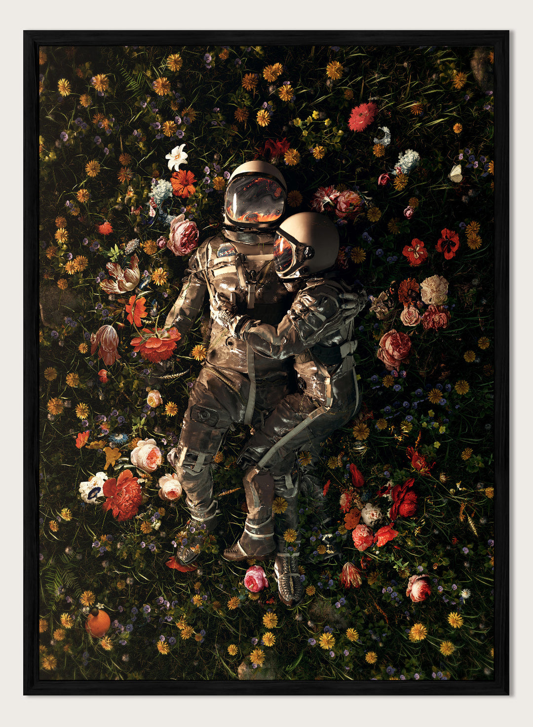 Astronaut lying on a bed of flowers with a dark background. Cosmic Couple Bloom by Nicebleed is a surreal astronaut floral art print featuring two astronauts in a field of flowers, modern aesthetic wall poster.