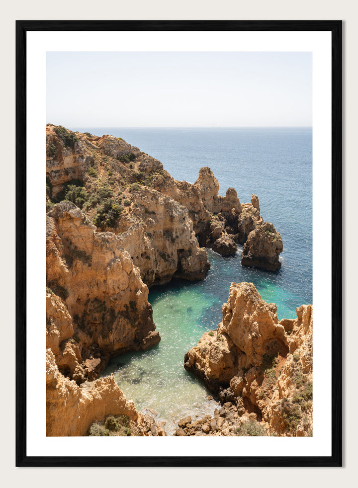 Rocky coastline with clear blue water. Golden Cliffs Azure Ocean by Henrike Schenk is a coastal photography print of rocky sea cliffs overlooking turquoise water and the Mediterranean coastline.