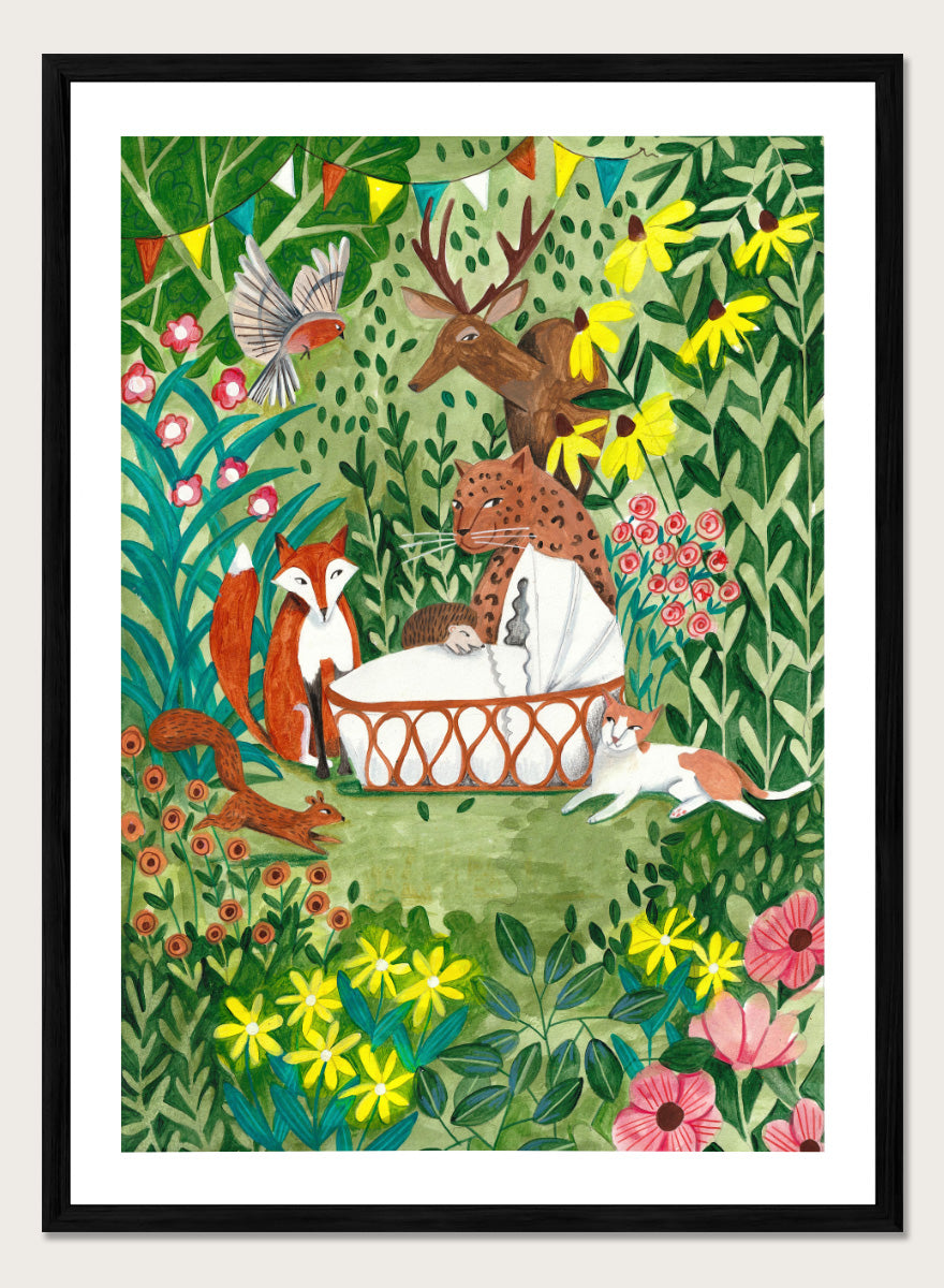 A framed art print featuring a whimsical forest illustration with animals gathered around a basket, surrounded by flowers and foliage. The print is shown with a white mat and a black frame against a white background. Welcome to the Forest by Caroline Bonne Müller woodland animal art print featuring a baby surrounded by a leopard, fox, deer, cat, flowers, and forest life.