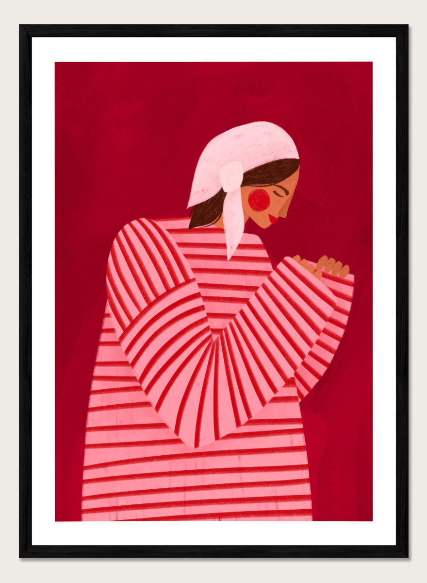 A framed art print featuring a stylized illustration of a woman in a pink and red striped top and white headscarf against a deep red background. Serene Praying Woman by Bea Müller portrait art print featuring a reflective woman in a pink striped dress against a rich red background.