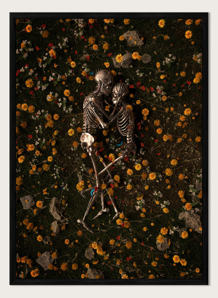 Skeletons In Love by Nicebleed is a surreal skeleton couple art print featuring intertwined skeletons in a floral field, modern aesthetic wall poster.