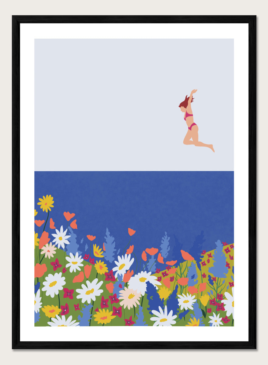 A framed art print featuring a minimalist illustration of a woman in a pink bikini jumping into a blue sea with a colorful wildflower meadow below. Wildflower Summer Jump art print by Ceyda Alasar features a joyful figure above colorful blooms, bringing playful summer energy to your walls.