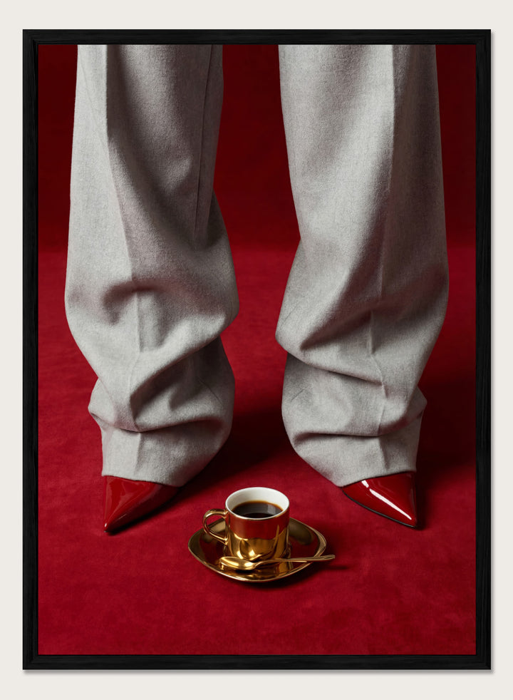 White pants with red shoes on a red carpet, featuring a gold cup and saucer with coffee. Red Shoes and Coffee by Andreas Magnusson is a fashion photography art print featuring red heels and espresso. Officially licensed modern wall poster.