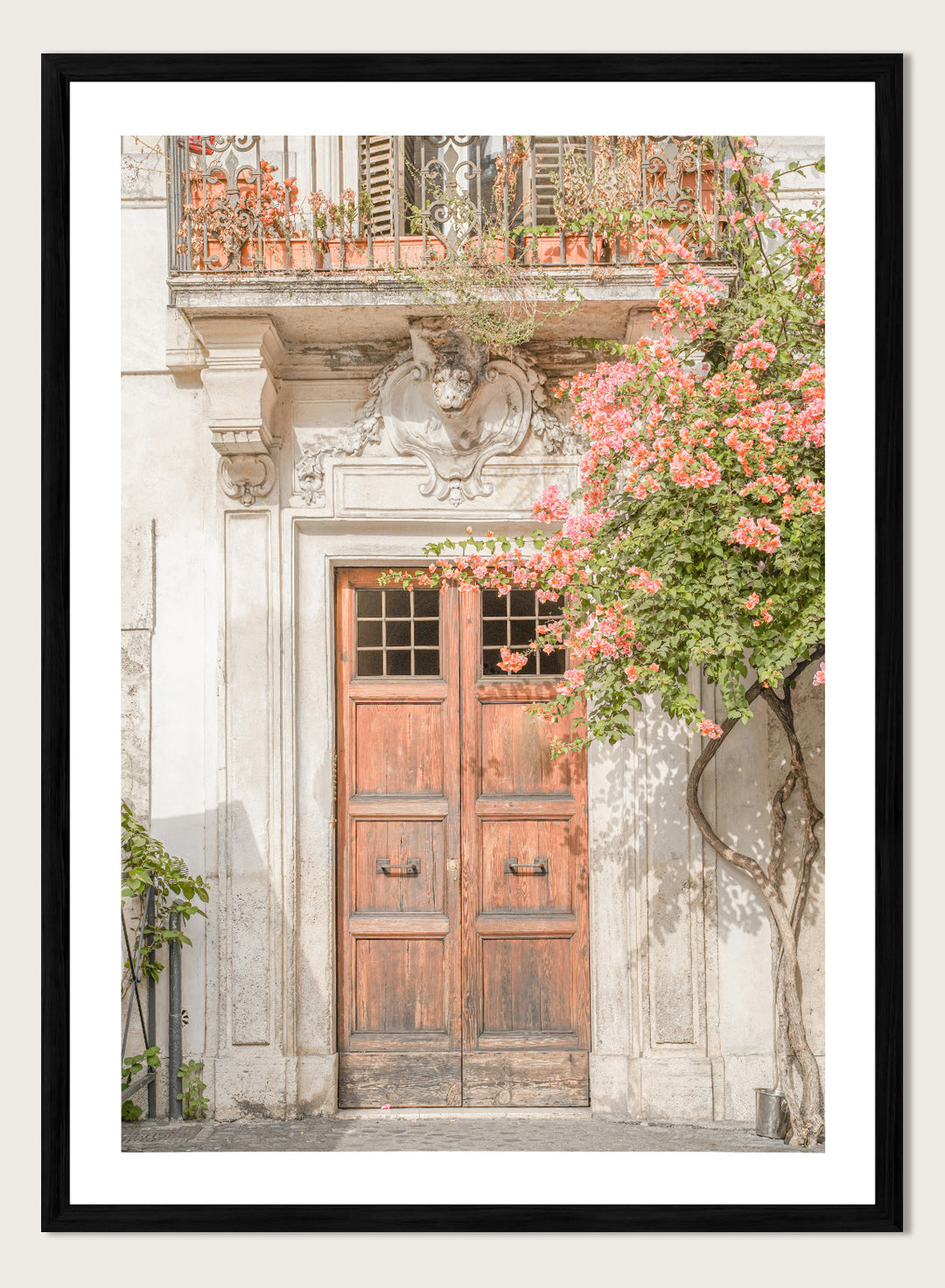 Wooden door with floral decorations on a building facade. Floral Entry by Henrike Schenk is a Mediterranean photography print featuring an old European doorway, blooming flowers, and historic architecture.
