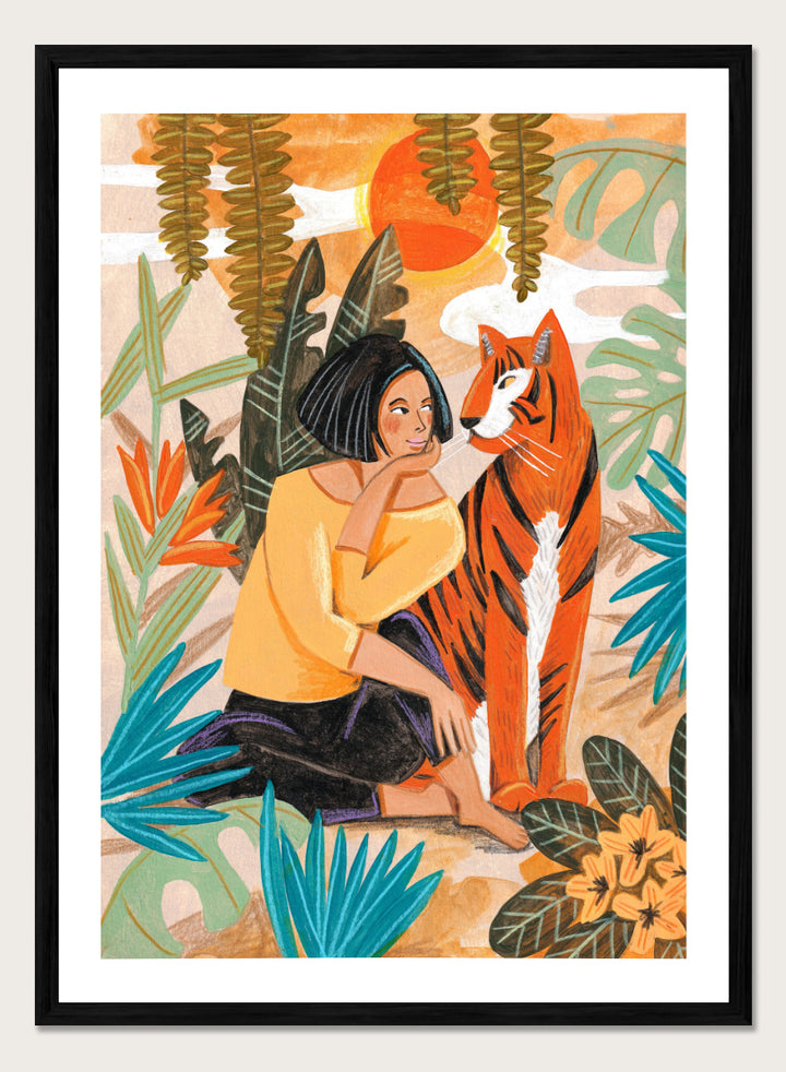 A framed art print featuring a stylized illustration of a woman in a yellow top and black skirt sitting beside an orange tiger, surrounded by tropical leaves and a warm orange sky. Woman with Tiger by Caroline Bonne Müller tropical art print featuring a woman beside a tiger among lush foliage, bold color, and hand-drawn texture.