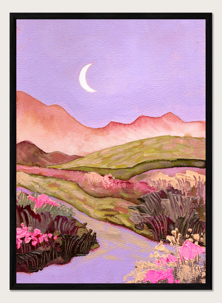 A landscape painting featuring rolling green hills, pink mountains, a purple sky with a crescent moon, and pink flowers along a winding path. Shop Moonlit Valley Path by Ekaterina Prisich, a colorful landscape art print featuring a crescent moon, winding path, rolling hills, and wildflowers.