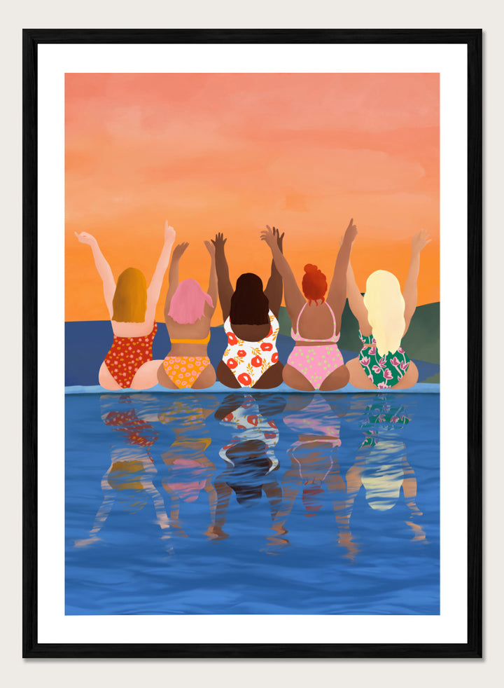 A framed art print featuring a stylized illustration of five women sitting in a pool at sunset, seen from behind as they raise their arms. The background is a warm orange sky, and the water below reflects their silhouettes. Summer Sunset Friends by Ceyda Alasar friendship art print featuring five women by the water in patterned swimsuits beneath a glowing orange sky.